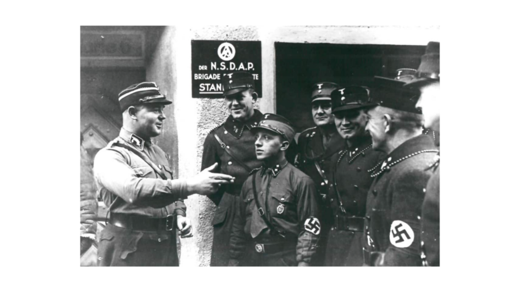 Nazi Germany: Ernst Röhm speaking to a group of SA men who are listening attentively.