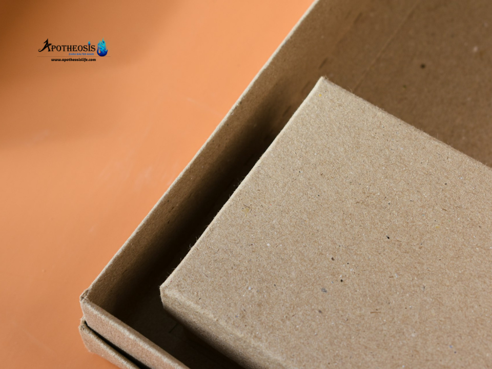 Two natural cardboard boxes stacked inside each other on an orange surface, showing simple sustainable packaging made from eco friendly materials.