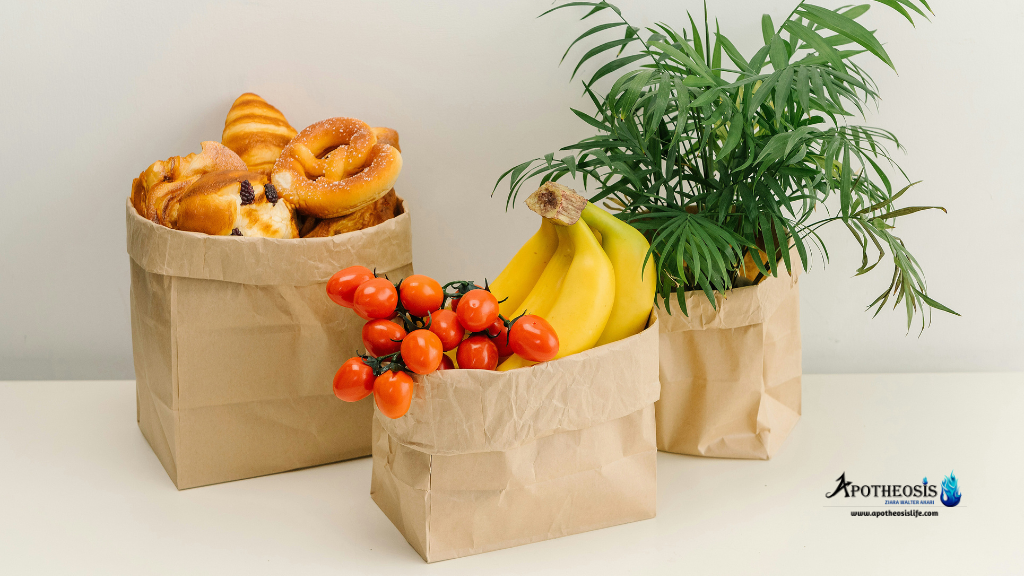 Three brown paper bags holding baked goods, fresh produce, and a leafy plant, illustrating practical sustainable packaging in everyday use.